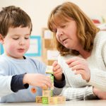 Dreghorn Pre-school and Creche pupil with teacher and building blocks