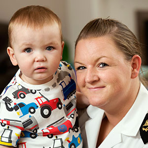 Navy mum smiling at camera with infant child