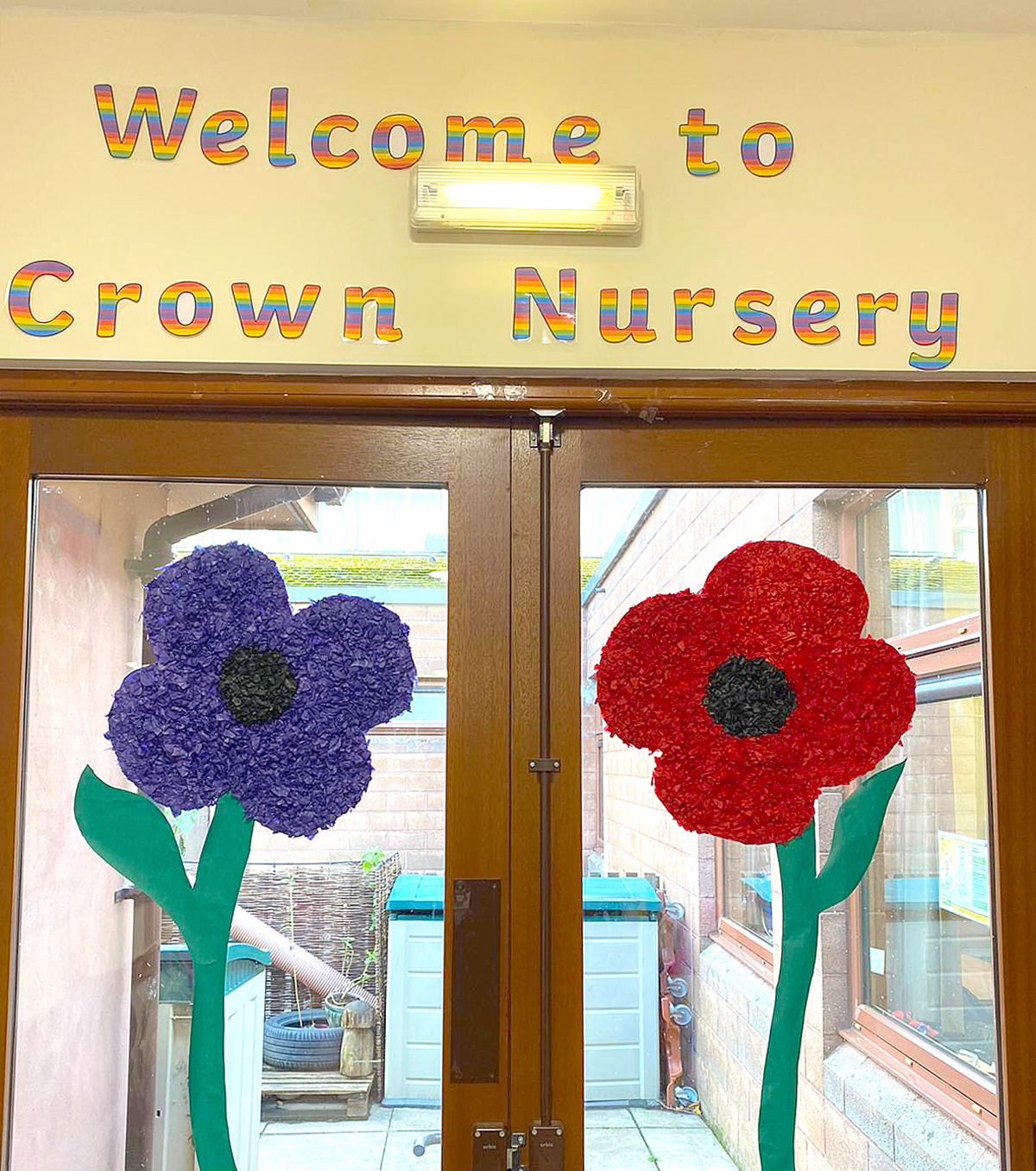 Two giant colourful poppies on the entrance doors to Crown Nursery