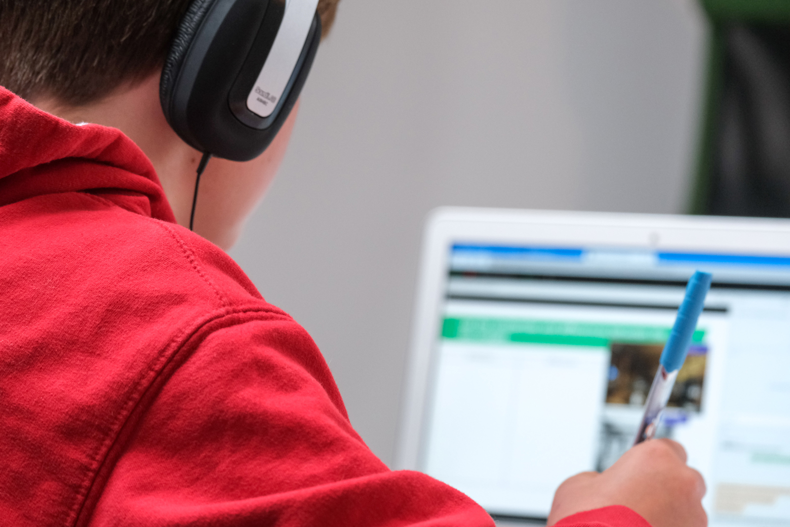 Teen in a red hoodie attending an online class