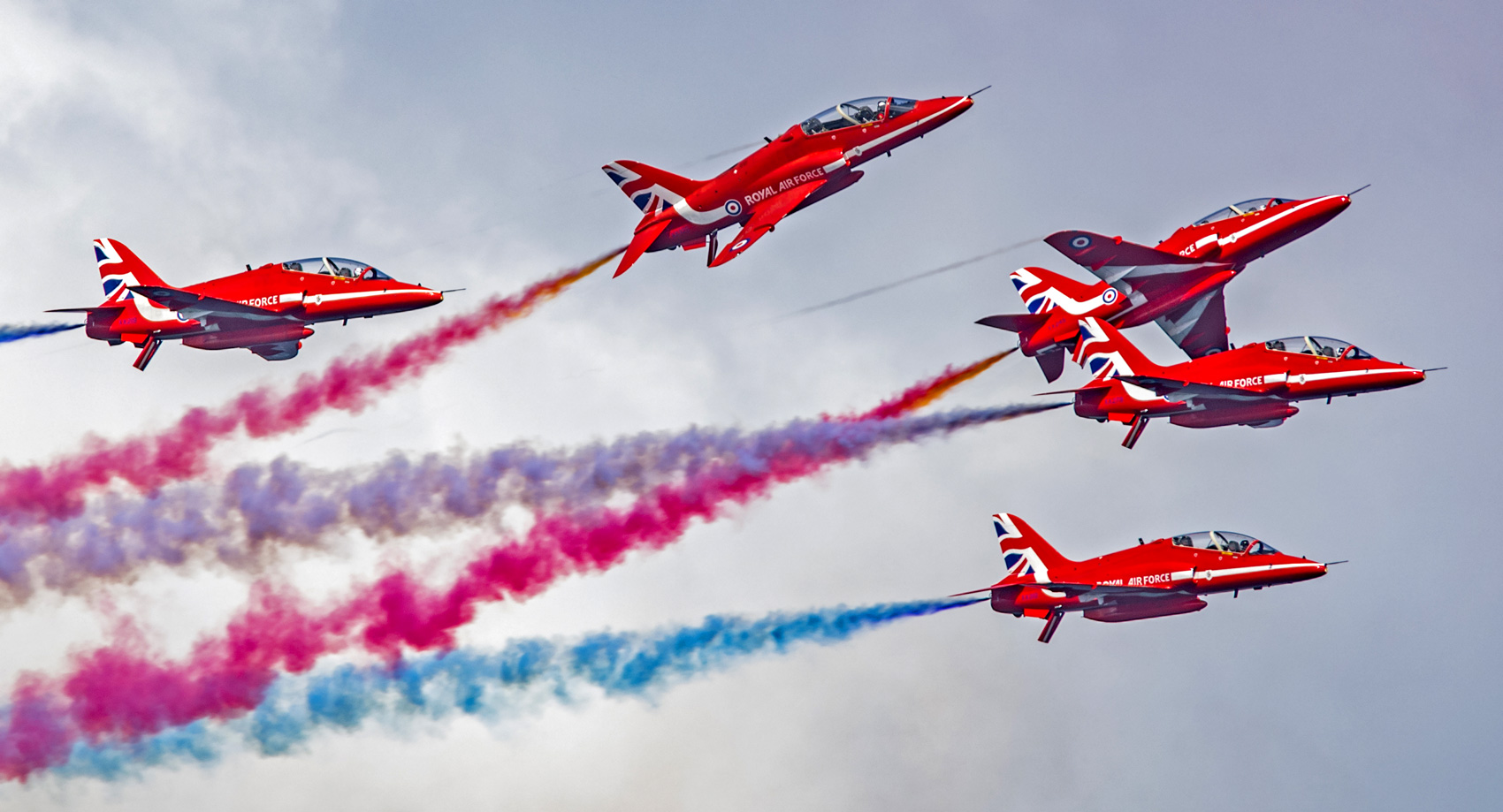 The red arrows aerobatics team flying with their signature coloured exhaust clouds