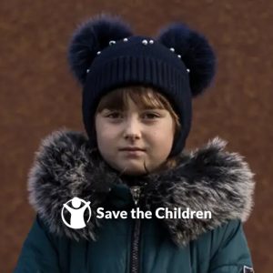 Little girl in winter coat with the Save the Children logo