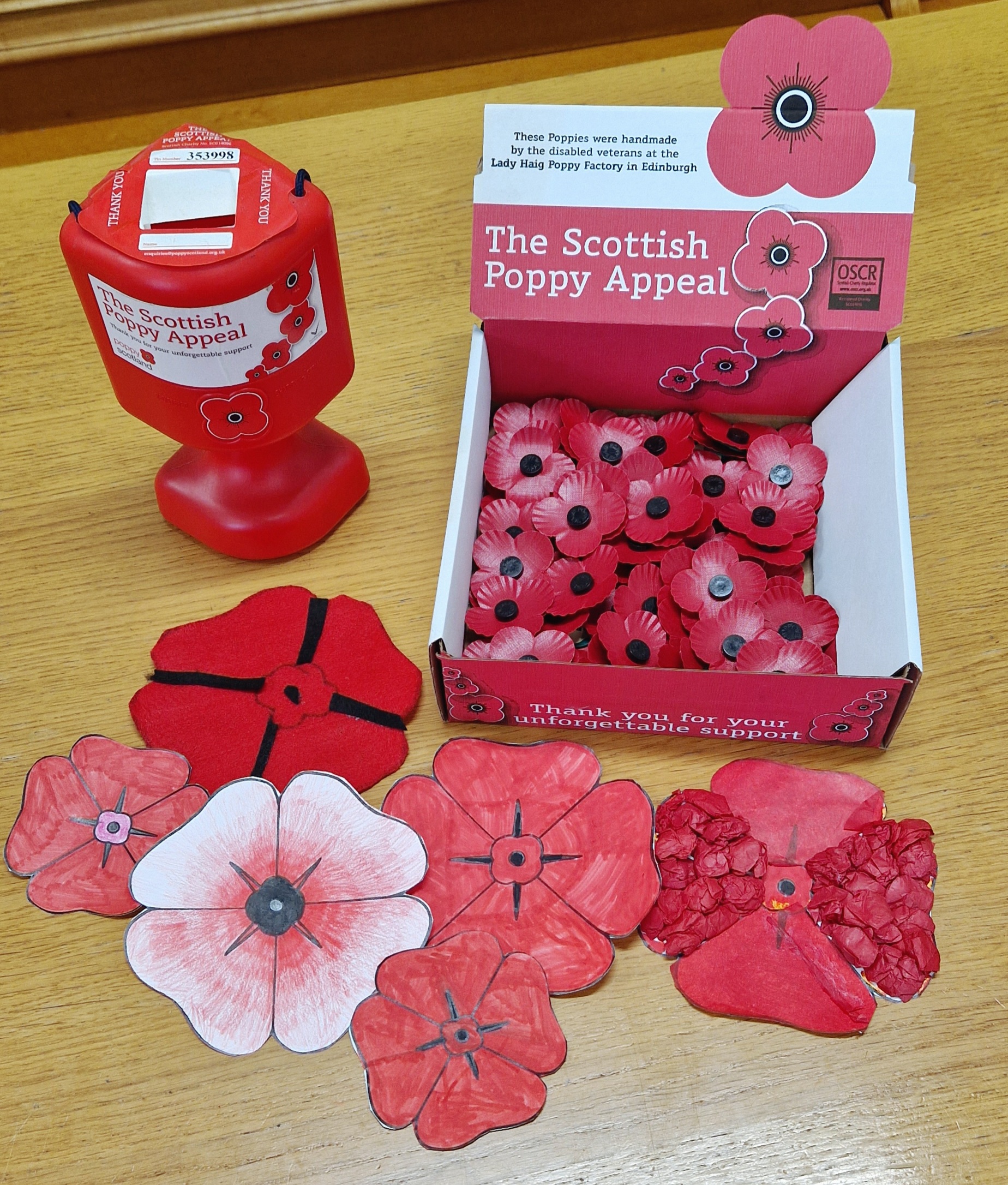 A poppy collection tin and box of poppies ready for sale