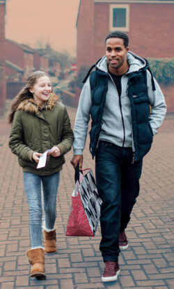 A dad and daughter walk home through their housing estate