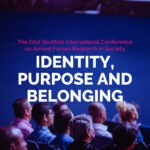 The words 'Identity, Prupose and belonging' float above an auditorium crowd all looking to the stage.