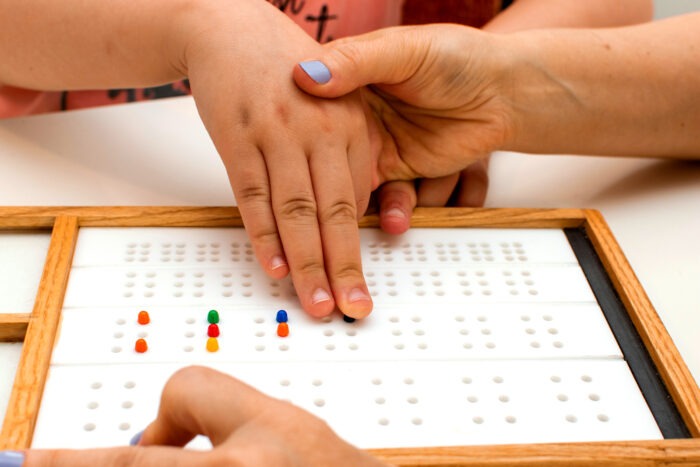 A child leans to read using braille pin boards.