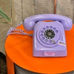 An old style rotary telephone with a label stating 'exam results helpline' on the front.